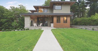 Long concrete sidewalk leading to the front door and porch area